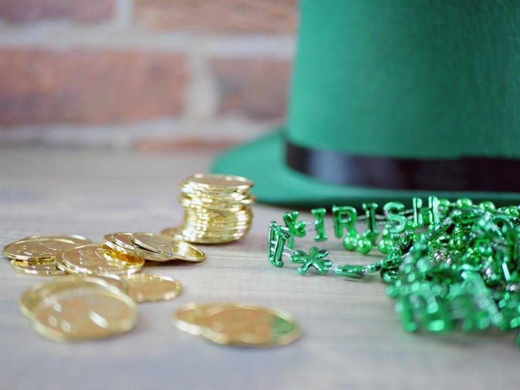 Close-up of gold coins and green beads with 'Irish' letters, perfect for St. Patrick's Day themes.