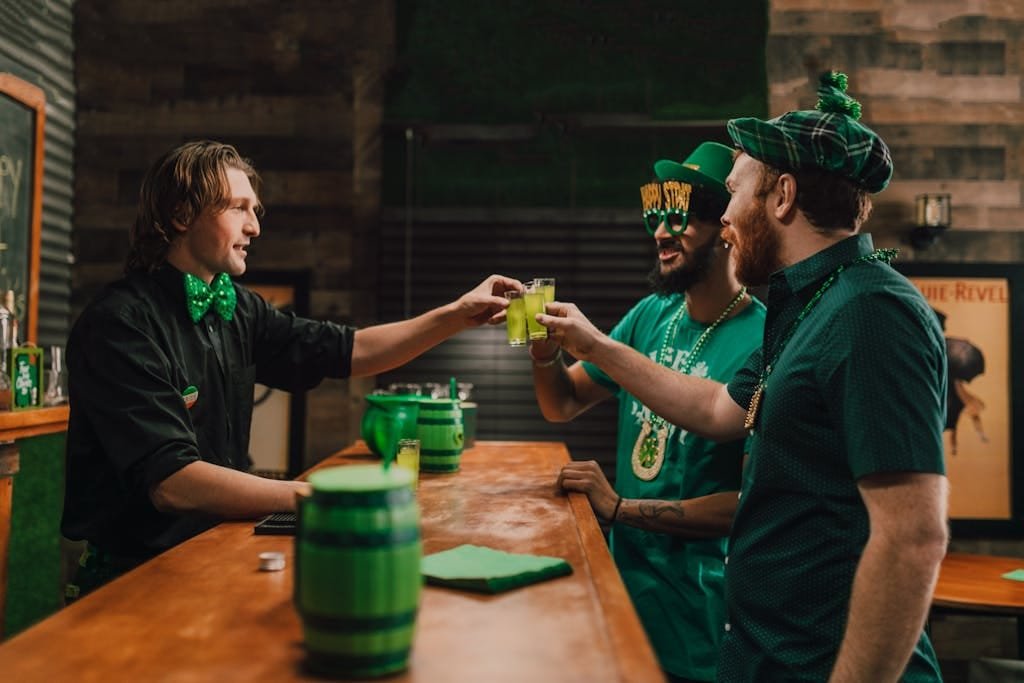 Joyful St. Patrick's Day celebration with friends toasting in an Irish pub.